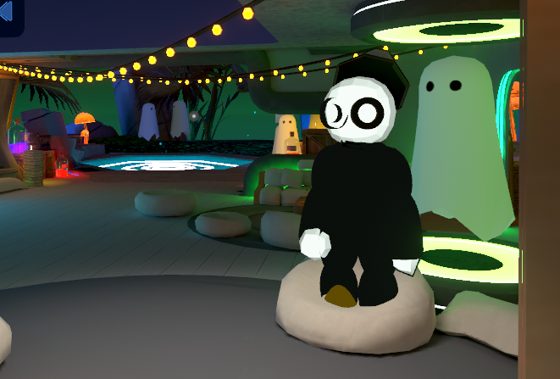 Captura de Roblox: un personaje de negro sentado en una escena nocturna con luces.